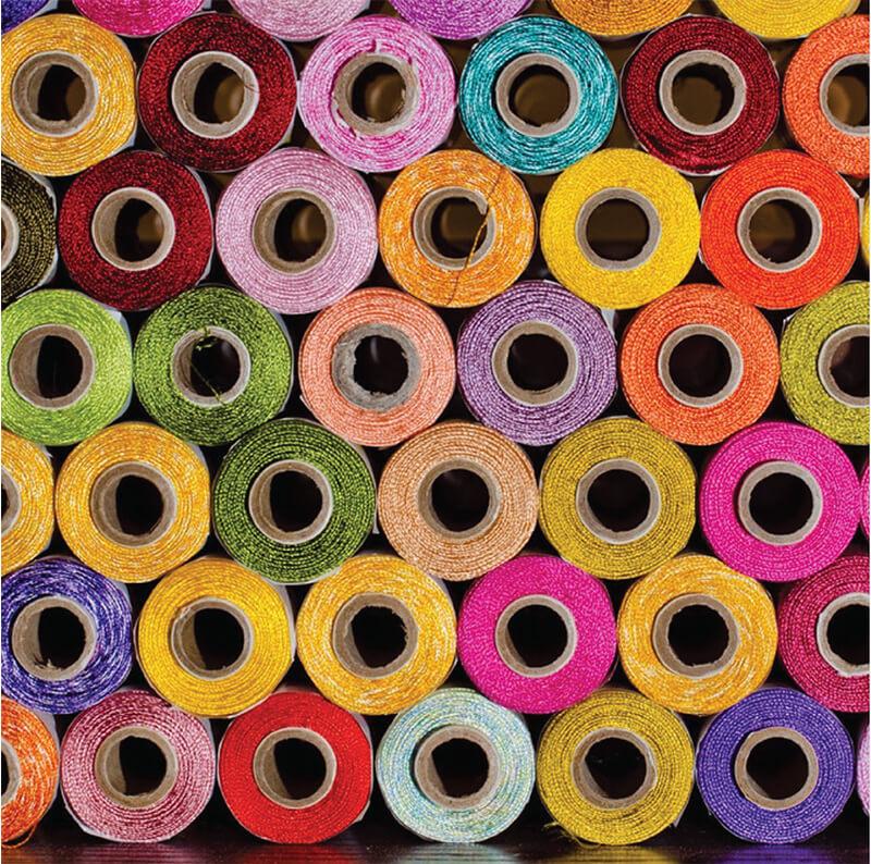 A group of spools of colorful fabric